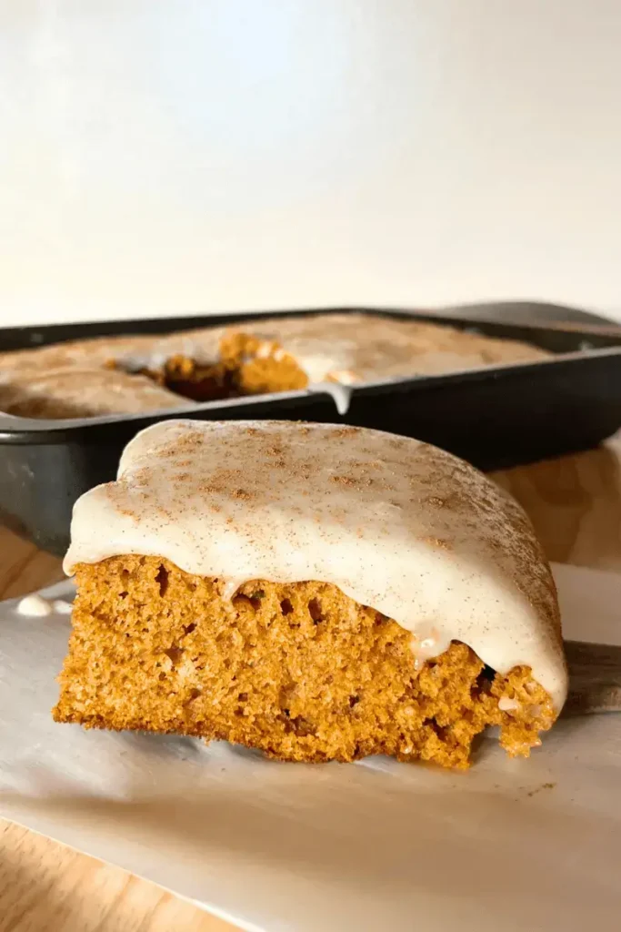 Close-up of frosted sourdough pumpkin spice bars showing soft, moist texture and creamy cream cheese frosting — perfect fall dessert.