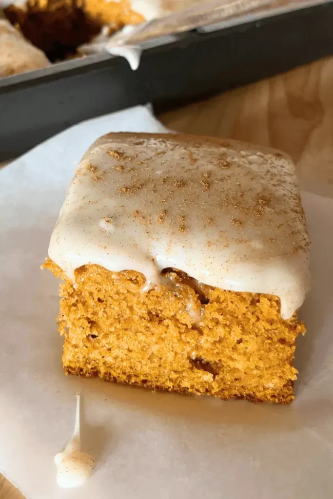 Close-up of frosted sourdough pumpkin spice bars showing soft, moist texture and creamy cream cheese frosting — perfect fall dessert.