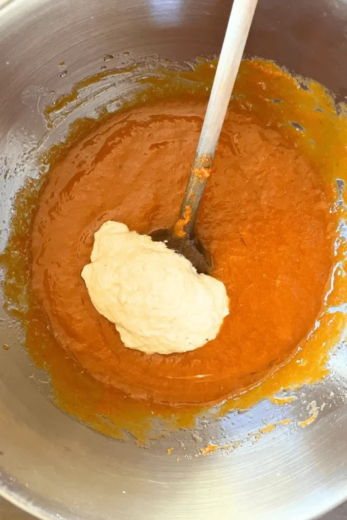 Whisking eggs, sugar, oil, pumpkin purée, and sourdough starter in a bowl — preparing batter for sourdough pumpkin spice bars.