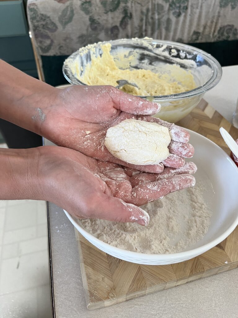 Girls hands forming sourdough cottage cheese pancakes drenched in flour. 