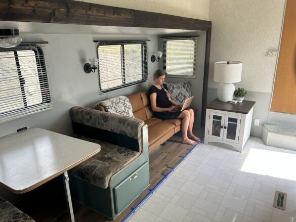 Girl working on computer in a remodeled 5th wheel.
