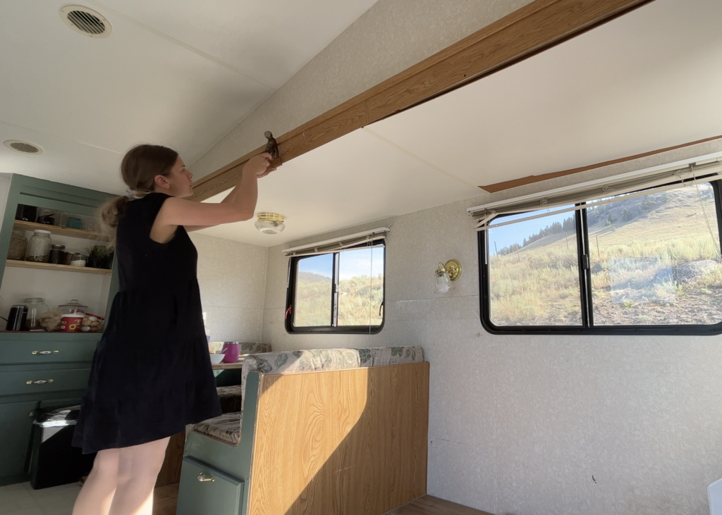 Girl removing trim from rv slide out to start remodeling.