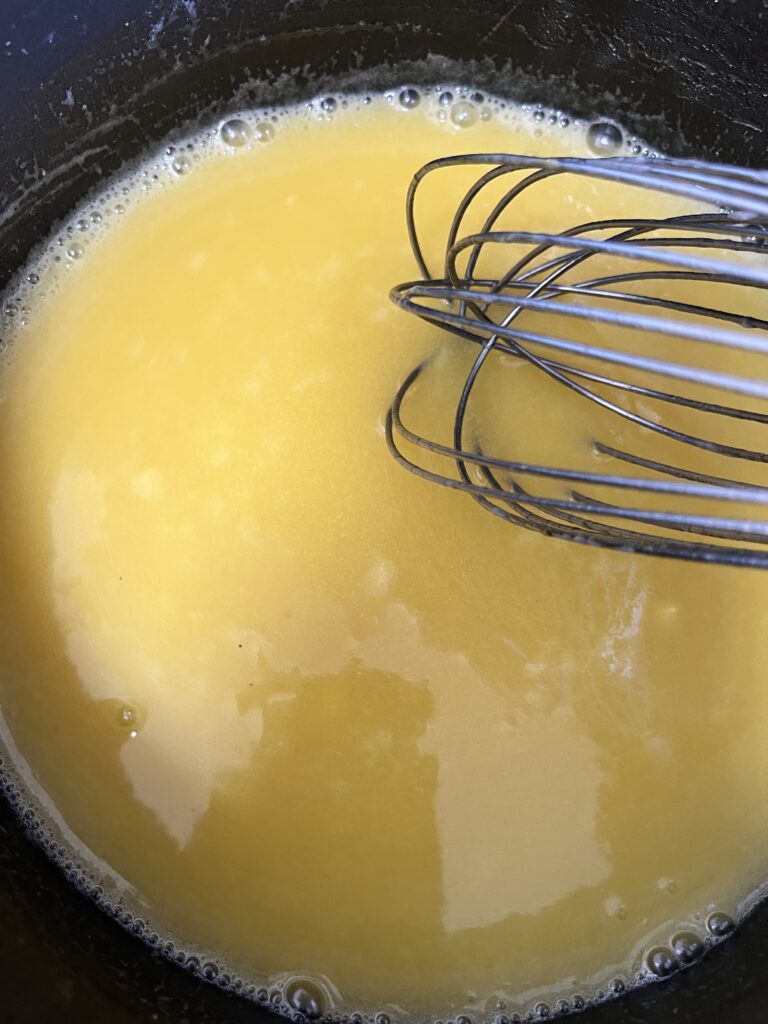 Mixing 2 beaten eggs into the melted butter and milk mixture for poppy seed filling. 