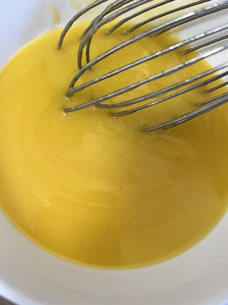 A whisk in an egg, milk, butter, sugar, salt mixture for poppy seed filling. 