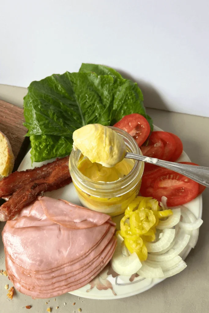Sourdough Ham and Cheese Sandwich ingredients on a cutting board.