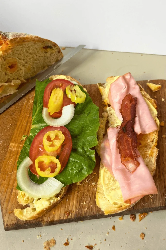 Sourdough Ham and Cheese Sandwich open faced with banana peppers, onions, tomatoes.