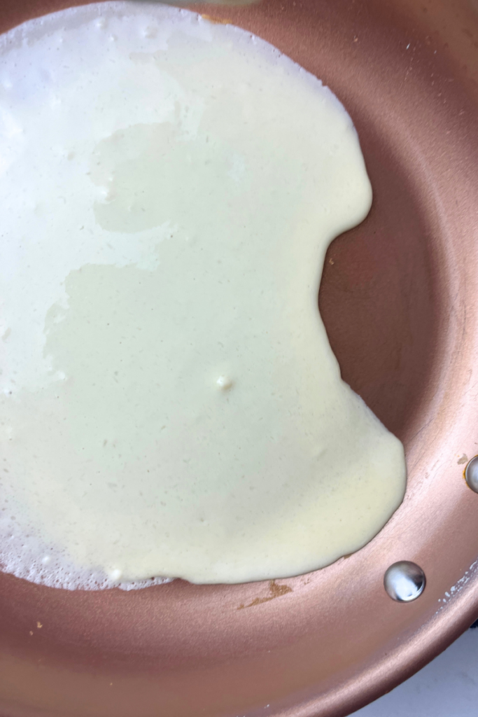 Sourdough crepe batter in a hot skillet.