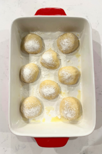Sourdough cherry cheesecake buns dough balls in a casserole pan.
