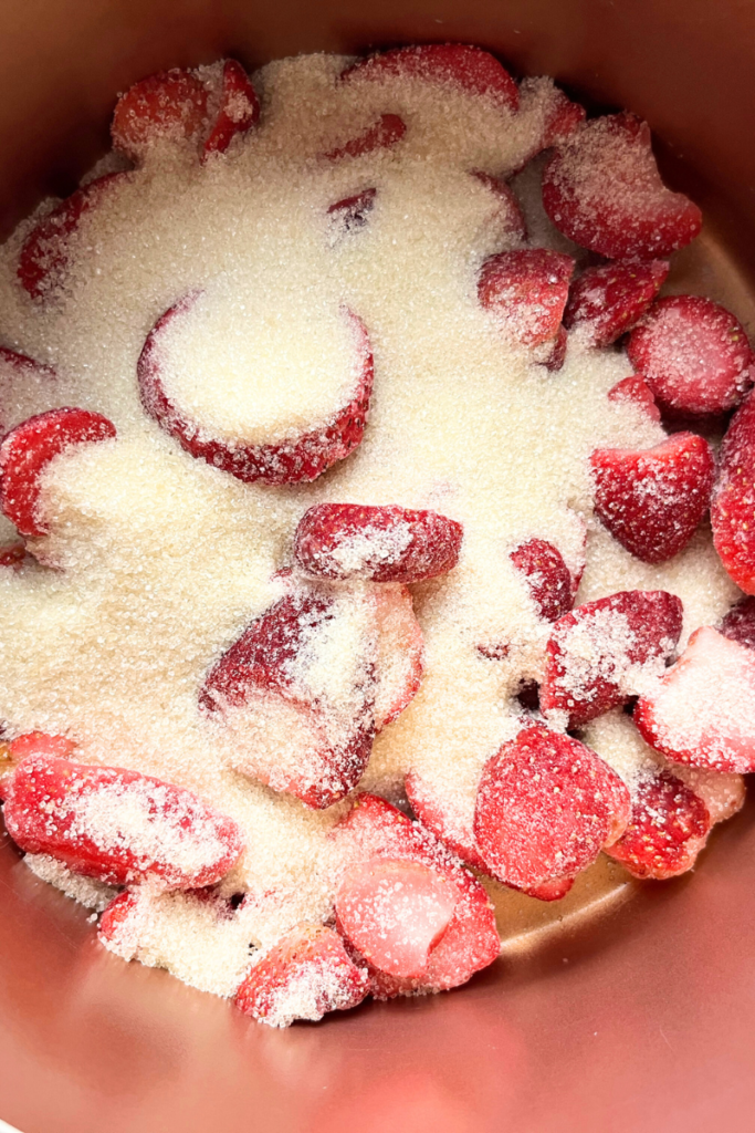 Strawberries and sugar in a pot.