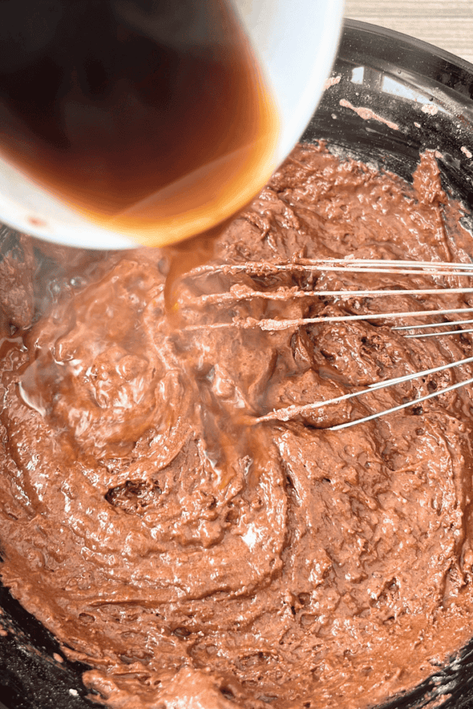 Adding hot coffee to sourdough chocolate sheet cake batter.