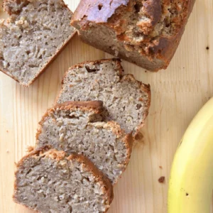Sourdough almond banana bread on a cutting board next to bananas.