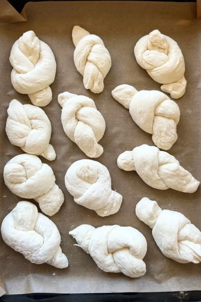 Sourdough garlic knots on a baking sheet for the final proof. 