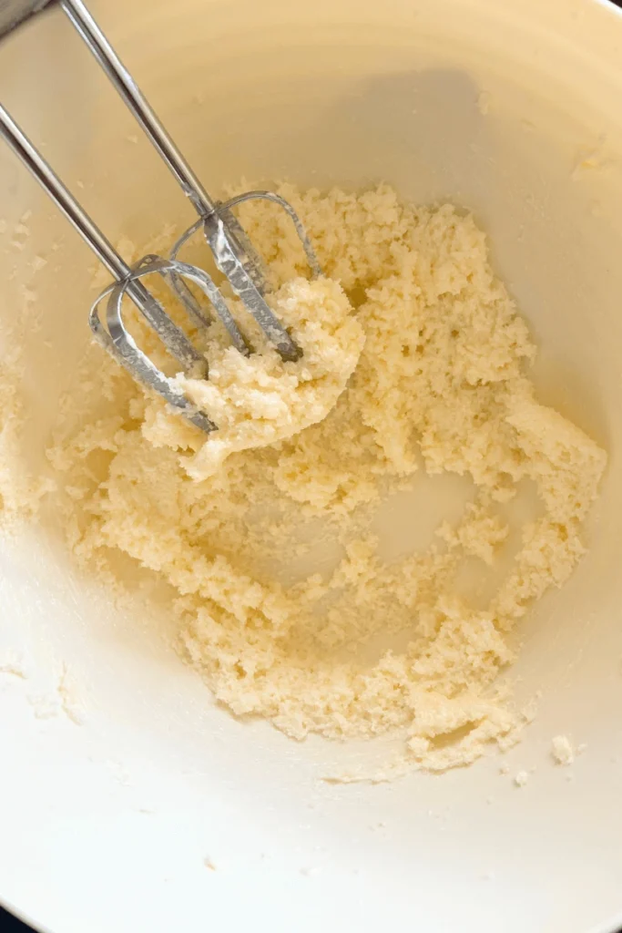 Butter and sugar beat together with a mixer for a sourdough snickerdoodle cake. 