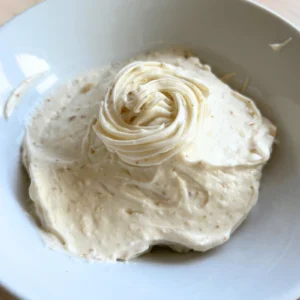Cream cheese frosting being whipped with browned butter and powdered sugar.
