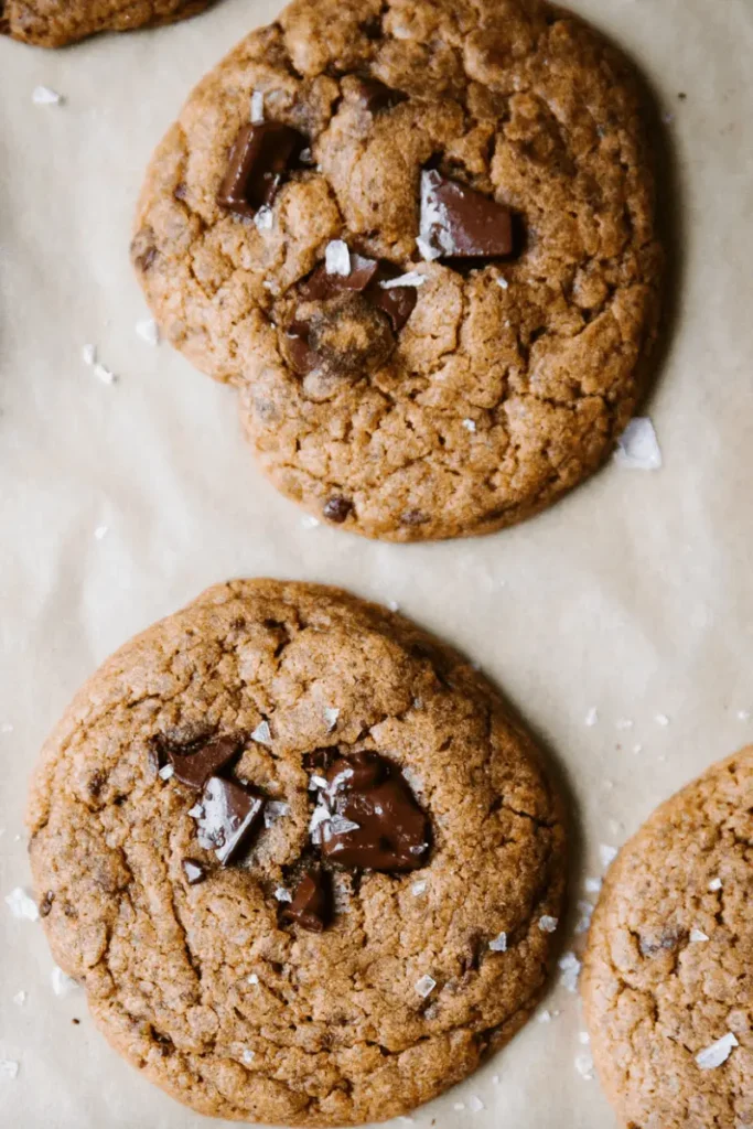 Vegan Sourdough Chocolate Chip Cookies on a parchment paper. 