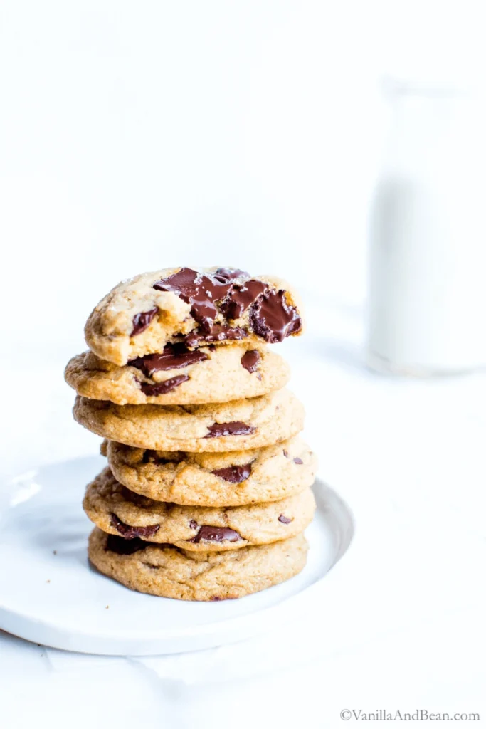 Sourdough Chocolate Chip Cookies stacked on a white plate. 