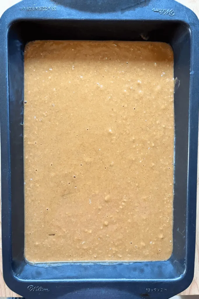 Batter in a 9x13 baking pan for Pumpkin Sourdough Tres Leches Cake.