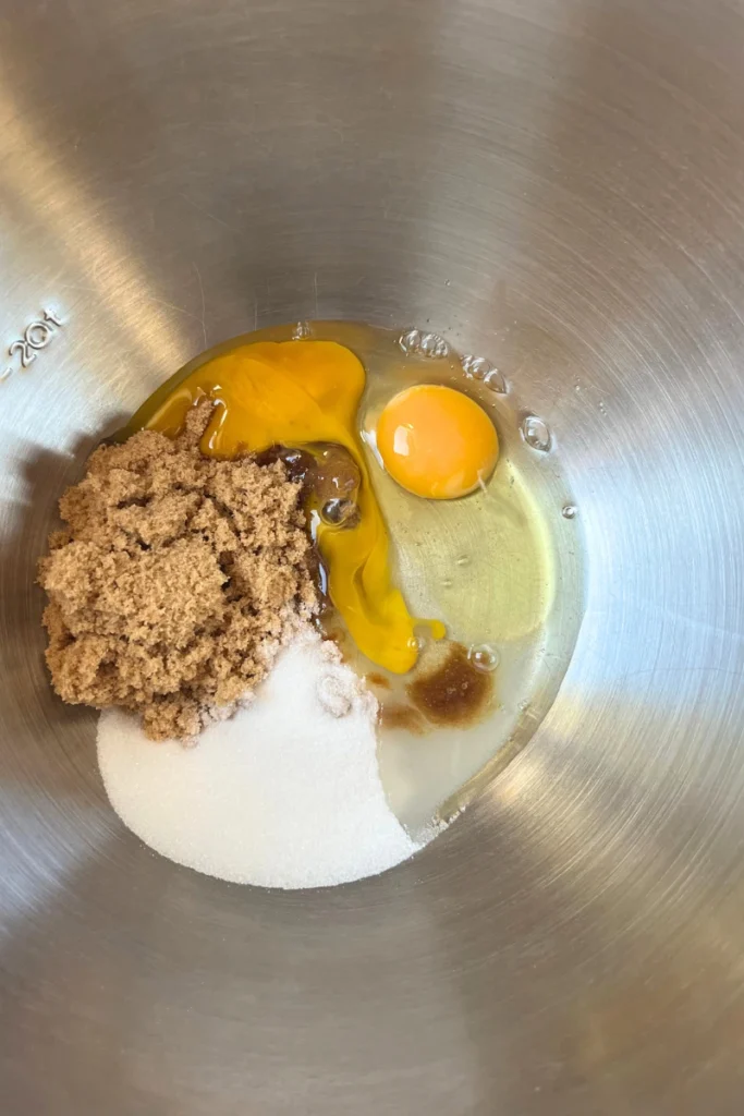 Sugar, egg, vanilla in a bowl for Sourdough Apple Cider Muffins.