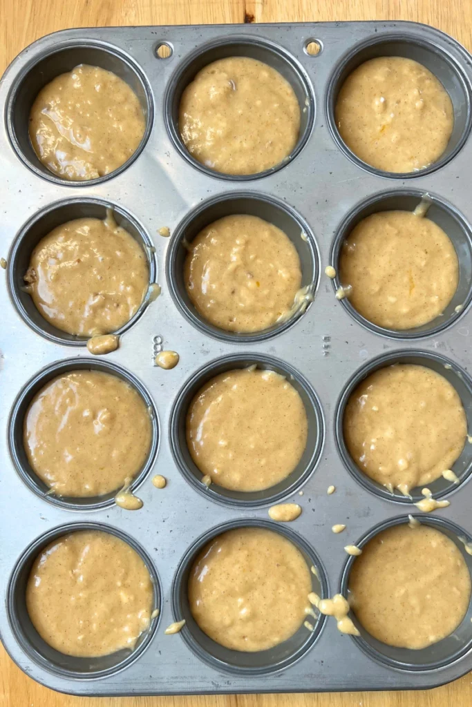 Sourdough Apple Cider Muffins in a muffin tin. 
