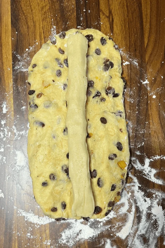 Sourdough stollen bread shaped into an oval with the homemade marzipan log in the center. 