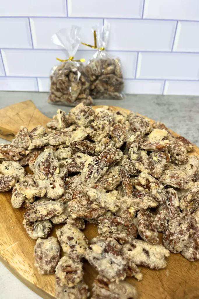 Close-up of homemade candied pecans coated in sugar and cinnamon on a cutting board. 