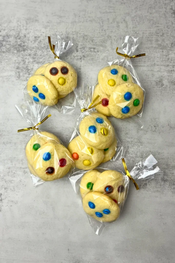 Soft sourdough sugar cookies with colorful M&Ms packaged in clear plastic wrap, ready for sale or as a gift.