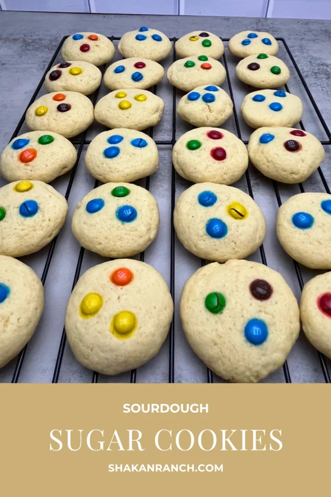 Stack of soft sourdough sugar cookies topped with colorful M&Ms on a cooling rack, perfect for baking, gifting, or enjoying as a sweet treat.