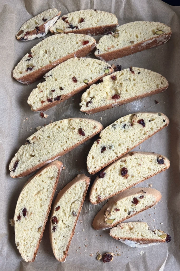 Sliced sourdough biscotti arranged on a baking sheet ready for the second bake.