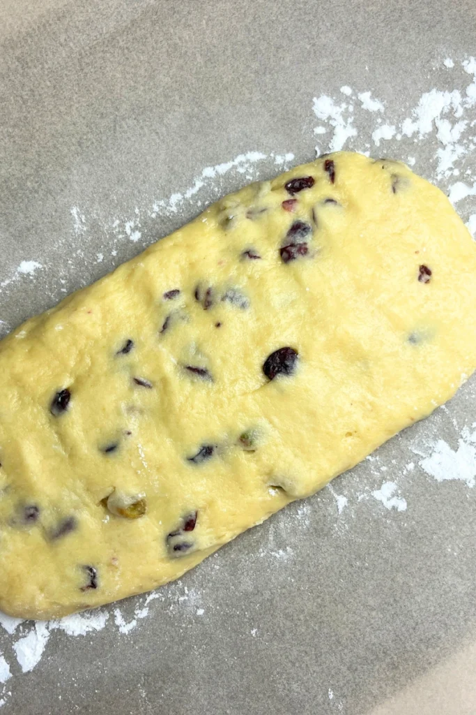 Cranberry pistachio sourdough biscotti dough shaped into logs on a lined baking sheet.