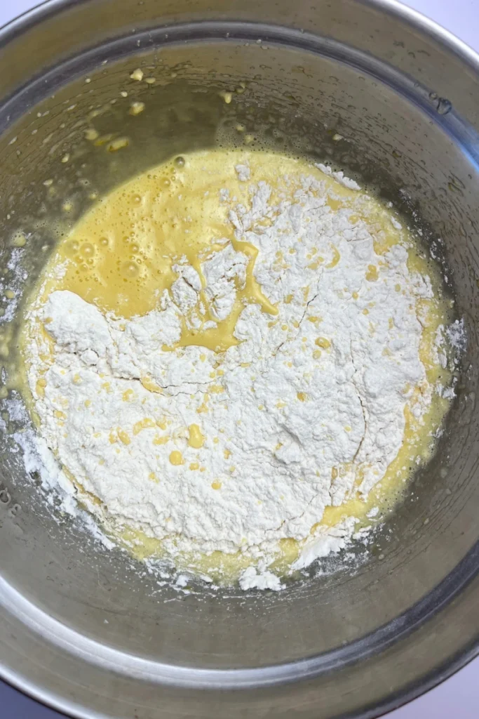 3 Adding flour to the sourdough cranberry almond thins batter.