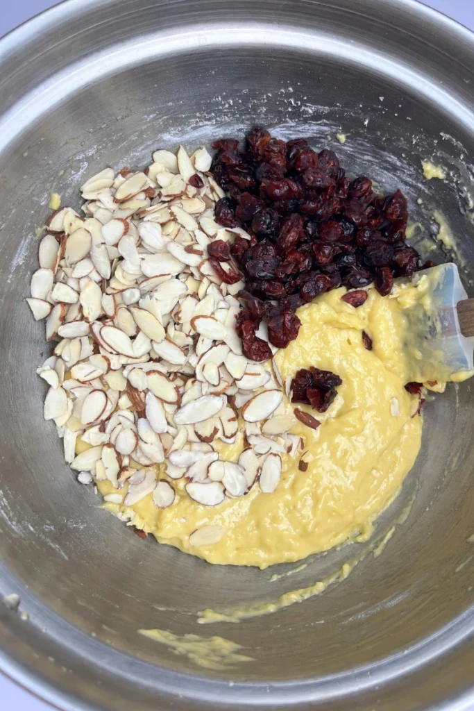 Folding sliced almonds and dried cranberries into sourdough cranberry almond thins batter.