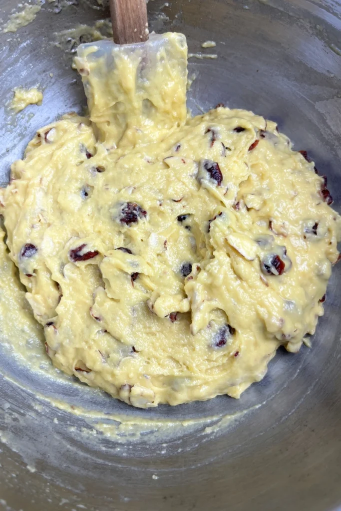 Adding sliced almonds and cranberries to sourdough discard cookie dough.