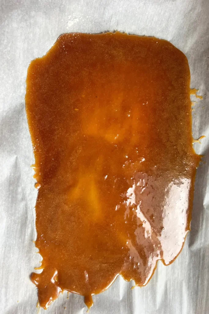 11 Ginger honey lemon chews mixture poured onto parchment paper to set.
