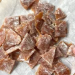 Finished ginger honey lemon chews arranged on parchment paper.