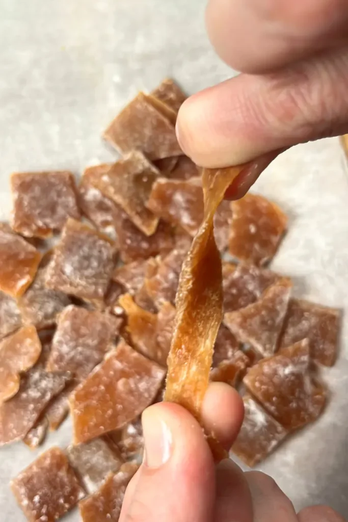 14 Sticky ginger honey lemon chews stretching while still warm and soft.