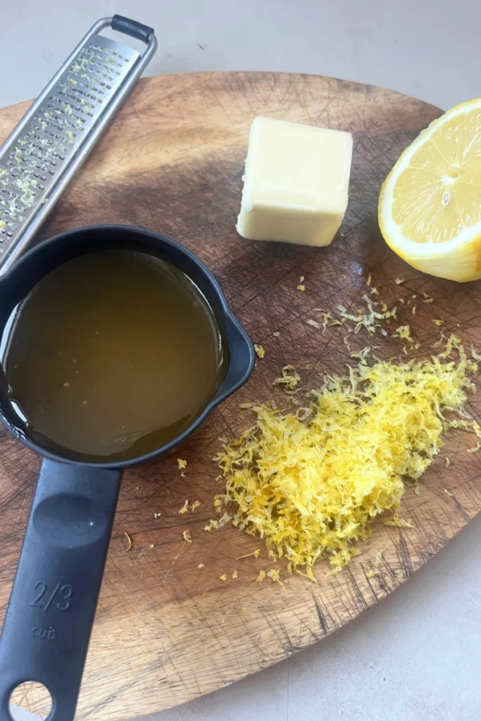 Ingredients for ginger honey lemon chews including fresh ginger, honey, lemon, and butter.