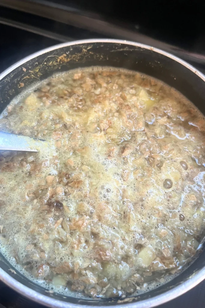 Blended ginger added to pot with water for ginger honey lemon chews.