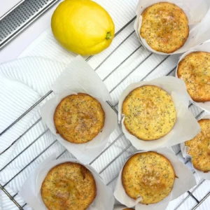 Soft and fluffy sourdough lemon poppy seed muffins with a golden top, made with sourdough discard on a cooling rack.