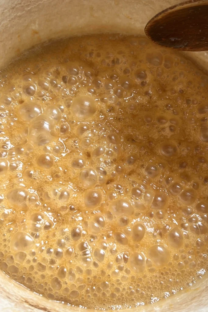 Bubbling ginger honey mixture cooking down for ginger lemon chews.